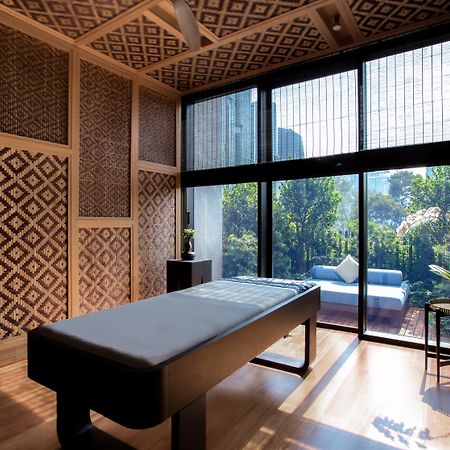 The Ruma Hotel And Residences Kuala Lumpur Exterior photo The photo displays a tranquil room designed for relaxation or therapy. The room features a massage table centered in the space, with elegant wooden accents. The walls are adorned with intricate geometric patterns, contributing to a serene atmosphere.