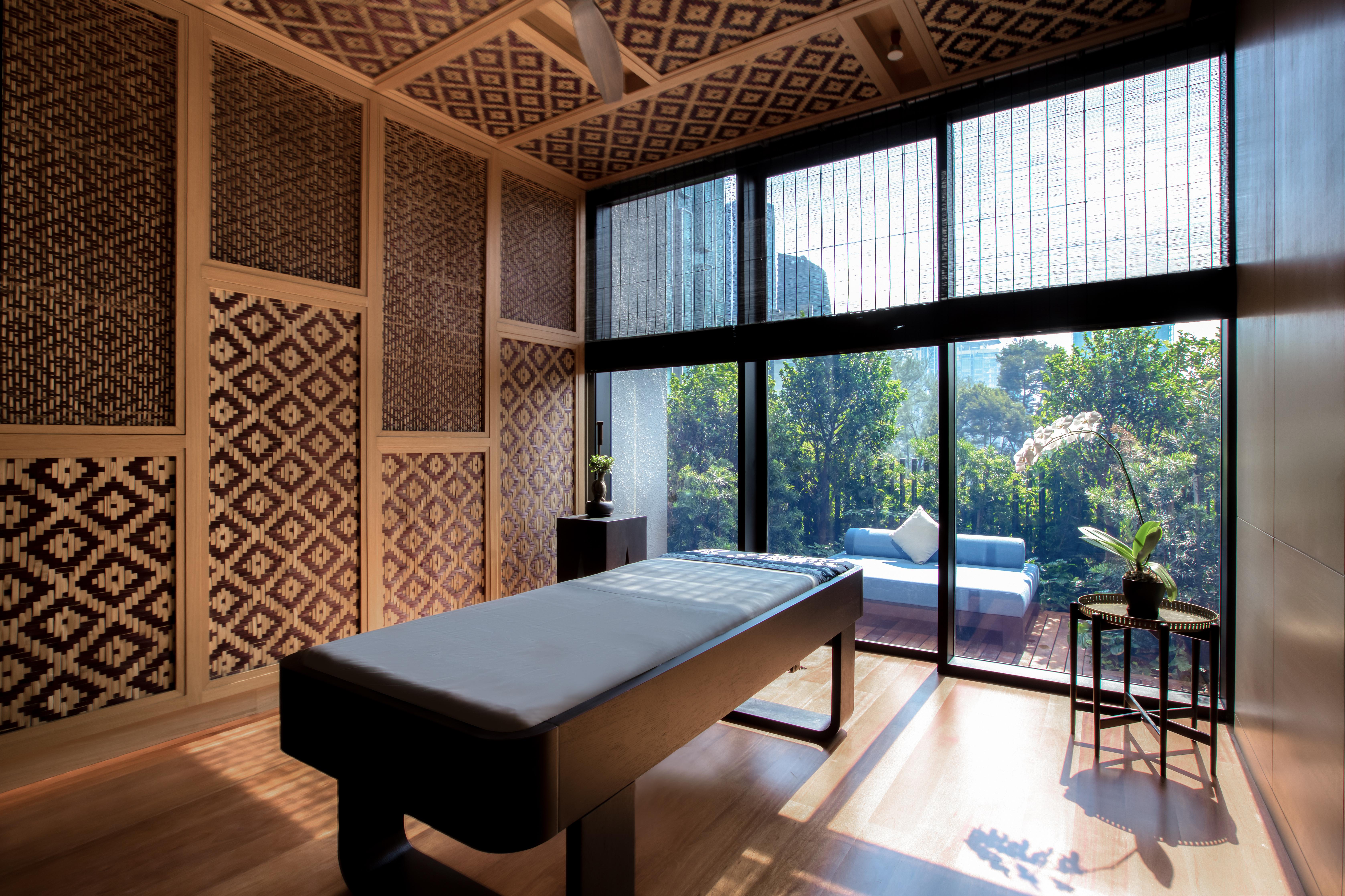The Ruma Hotel And Residences Kuala Lumpur Exterior photo The photo displays a tranquil room designed for relaxation or therapy. The room features a massage table centered in the space, with elegant wooden accents. The walls are adorned with intricate geometric patterns, contributing to a serene atmosphere.